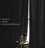 A dark gray curtain is partially open, revealing a window and a small decorative table with a golden geometric stand and a black figurine. Produktbild-Vorschau