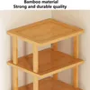 Close-up of a multi-tiered corner shelf made of bamboo, set against a light-colored wall. Produktbild-Vorschau