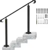 A black metal handrail for stairs is shown installed on a set of three simulated concrete steps. The handrail is angled, with two vertical posts supporting it. To the right of the handrail, a collection of hardware, including bolts, screws, a drill bit, an Podgląd zdjęcia produktu