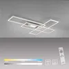 A modern LED ceiling light fixture with a geometric design, shown mounted on a gray ceiling. Below the fixture, there are visual representations of color temperature and brightness adjustments, along with a remote control. Produktbild-Vorschau