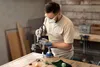 A person is using a Dremel tool to work on a small object. Produktbild-Vorschau