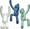 Three wall hooks shaped like stylized human figures in white, blue, and green. Náhled obrázku produktu