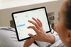 A person is using a tablet, with a small device attached to the side. Anteprima dell’immagine prodotto