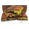 A stack of chocolate bars filled with a green, shredded filling. Produktbild-Vorschau