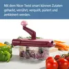 A food chopper with various vegetables and carrots arranged around it on a white surface. Anteprima dell’immagine prodotto