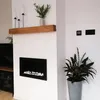 A modern living room with a fireplace and a plant. Náhled obrázku produktu