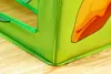 Close-up of the corner of a green play tent with a cartoonish orange and yellow design on it, resting on a wooden floor. Náhled obrázku produktu