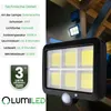 A solar-powered outdoor light with a motion sensor, mounted on a wooden structure. Produktbild-Vorschau
