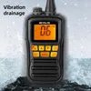 A black Retevis RM01 marine walkie talkie is shown partially submerged in water, with water splashing around it. Voir les images du produit