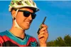 A man wearing a helmet and sunglasses is holding a walkie-talkie. Náhled obrázku produktu