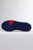 The bottom view of a blue Adidas sneaker with red accents. Produktbild-Vorschau