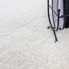 A close-up view of a fluffy white shaggy carpet. Anteprima dell’immagine prodotto