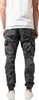 Back view of a person wearing camouflage cargo pants and white sneakers. Produktbild-Vorschau