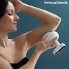A woman is using a white massage device on her arm. Produktbild-Vorschau