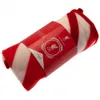 A rolled-up fleece blanket with red and white stripes, presented in its packaging. Náhľad obrázku produktu