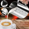 A hand is pouring frothed milk from a stainless steel pitcher into a white coffee cup, creating latte art. Anteprima dell’immagine prodotto