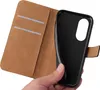 A hand holding a black phone case next to a brown wallet-style phone case. Produktbild-Vorschau