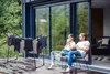 A couple relaxing on a deck with a drying rack in the foreground. Produktbild-Vorschau