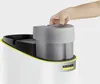 A hand is shown placing a component onto a white cleaning appliance with yellow trim. Voir les images du produit