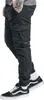 A person wearing black cargo pants and black and white sneakers. Produktbild-Vorschau