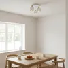 A dining table with chairs, set for breakfast with steaming cups of coffee and croissants, under a modern ceiling light. Produktbild-Vorschau