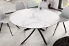 A round dining table with a marble-like top and a black metal base, surrounded by four gray upholstered chairs in a dining room setting. Produktbild-Vorschau