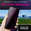 A hand holding a smartphone in front of a cityscape. Produktbild-Vorschau