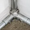 A close-up view of the corner joint of a tent or shelter structure, showing metal poles and a white fabric covering. Produktbild-Vorschau