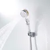 A chrome shower head with a water stream spraying from it, mounted on a white wall. Produktbild-Vorschau