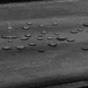 A close-up shot of water droplets on a black fabric surface, likely demonstrating a water-repellent feature. Náhľad obrázku produktu