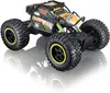 A remote-controlled rock crawler car with large tires and a colorful body, shown on a reflective surface against a white background. Voir les images du produit