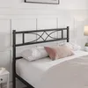 A close-up view of a black metal bed frame headboard with pillows on the bed. Produktbild-Vorschau