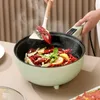 Hellgrüner elektrischer Topf, der ein Krebsgericht mit Zitrone und Kräutern kocht, eine Hand rührt mit einem Spatel um Produktbild-Vorschau