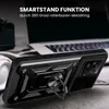 A black smartphone case with a ring stand is shown in a close-up shot, with a laptop and headphones blurred in the background. Produktbild-Vorschau