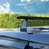 A close-up view of a car's roof rack system against a backdrop of green foliage and a blue sky with clouds. Podgląd zdjęcia produktu