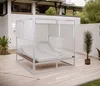 A modern outdoor lounge daybed with white cushions and a white canopy, set on a light-colored wooden deck with potted plants. Produktbild-Vorschau