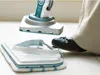 A person is using a steam mop on a tiled floor. Voir les images du produit