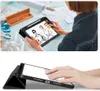 A person is using a tablet for digital art, with art supplies scattered around. Náhľad obrázku produktu