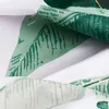 A close-up view of fabric with a green banana leaf pattern. Podgląd zdjęcia produktu