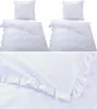 A set of white bedding with ruffles, including two duvet covers and two pillowcases, displayed against a white background. Produktbild-Vorschau