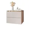 A modern, minimalist bedside table with two drawers, decorated with a vase of dried flowers and perfume bottles.