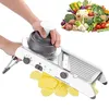 A person is using a mandoline vegetable slicer to cut potatoes into waffle-cut slices. A pile of fresh vegetables is visible in the background. Produktbild-Vorschau