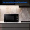 A black microwave oven is displayed on a kitchen counter with a tiled backsplash and cabinetry below. Produktbild-Vorschau