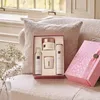 A gift set of skincare products arranged on a textured surface, with a decorative pink box nearby. Produktbild-Vorschau