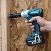 A hand holding a Makita impact wrench, using it to fasten a bolt into a wooden structure. Podgląd zdjęcia produktu