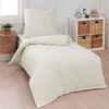 A neatly made bed with cream-colored bedding in a bedroom setting. Produktbild-Vorschau
