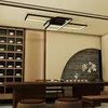 A modern interior scene with a tea set on a wooden table, a decorative wall, and a geometric ceiling light. Voir les images du produit