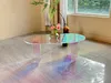 An iridescent acrylic coffee table with a vase of flowers and a fern on it, placed on a tiled floor near a window. Anteprima dell’immagine prodotto