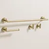 A set of bathroom hardware, including a towel bar, toilet paper holder, and two hooks, mounted on a light-colored wall. Produktbild-Vorschau