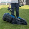 A person is folding the handle of a black and blue lawnmower on a grassy lawn. Podgląd zdjęcia produktu
